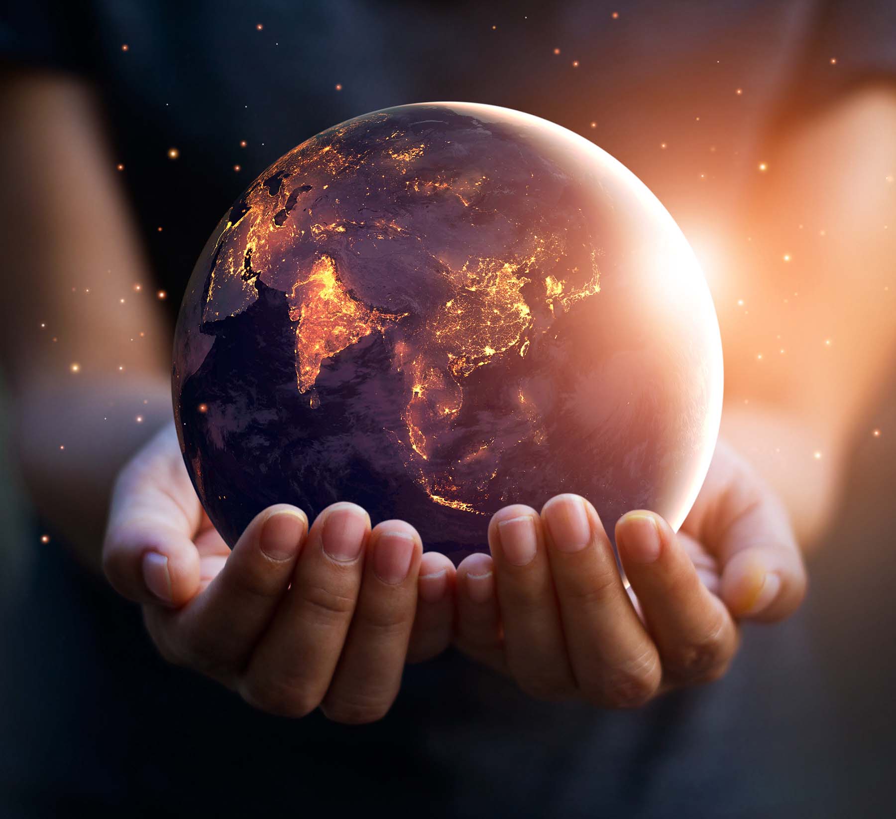 Young hands holding a glowing planet Earth